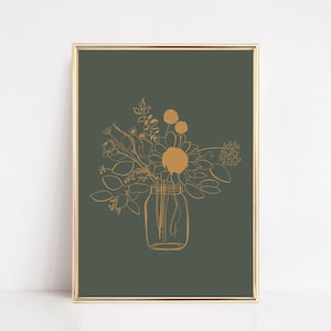May include: A framed wall art print featuring a dark olive green background with a gold-colored line drawing of a bouquet of various flowers and leaves arranged inside a glass mason jar. The frame is thin and metallic gold in color.