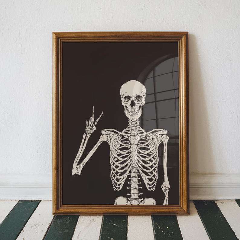K&ouml;nnte beinhalten: Ein gerahmter Kunstdruck mit einer detaillierten Illustration eines menschlichen Skeletts vor einem einfarbigen schwarzen Hintergrund. Das Skelett ist ab dem Oberk&ouml;rper dargestellt, wobei der rechte Arm erhoben ist und die Finger ein Friedenszeichen formen.