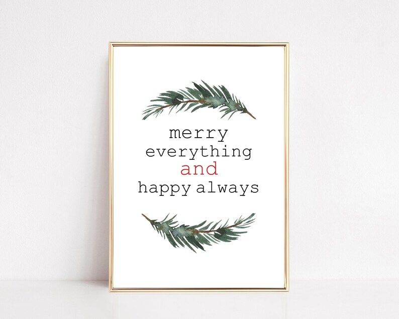 May include: A framed print with a gold border features the text "merry everything and happy always" in black and red. Watercolor sprigs of evergreen branches are above and below the text, creating a festive holiday theme.