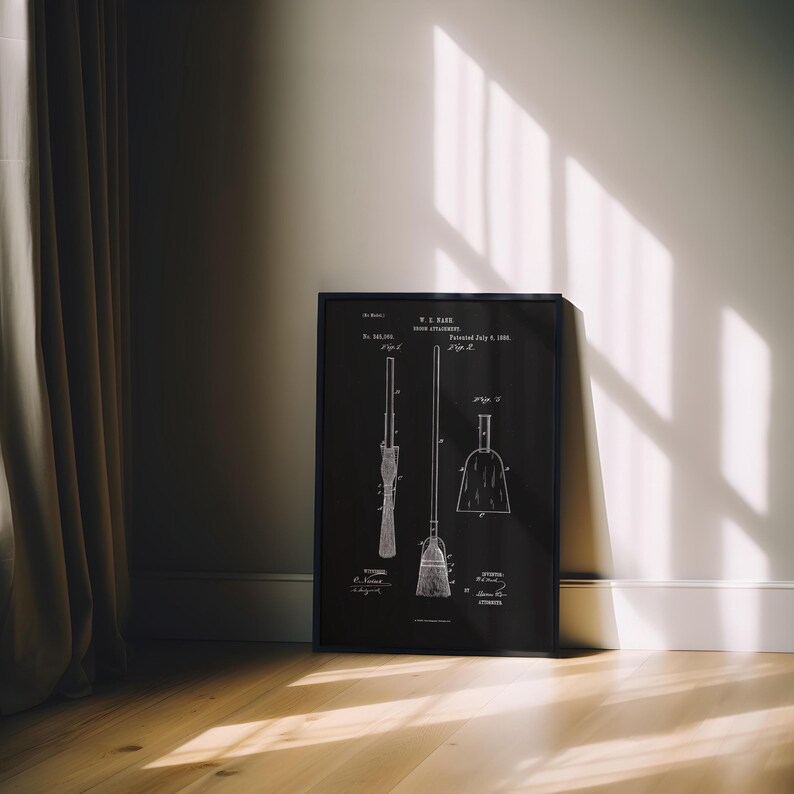 May include: A framed black and white print of a broom patent diagram. The print shows detailed illustrations of a broom, dustpan, and related components. The frame is black, and the print is displayed on a wooden floor.