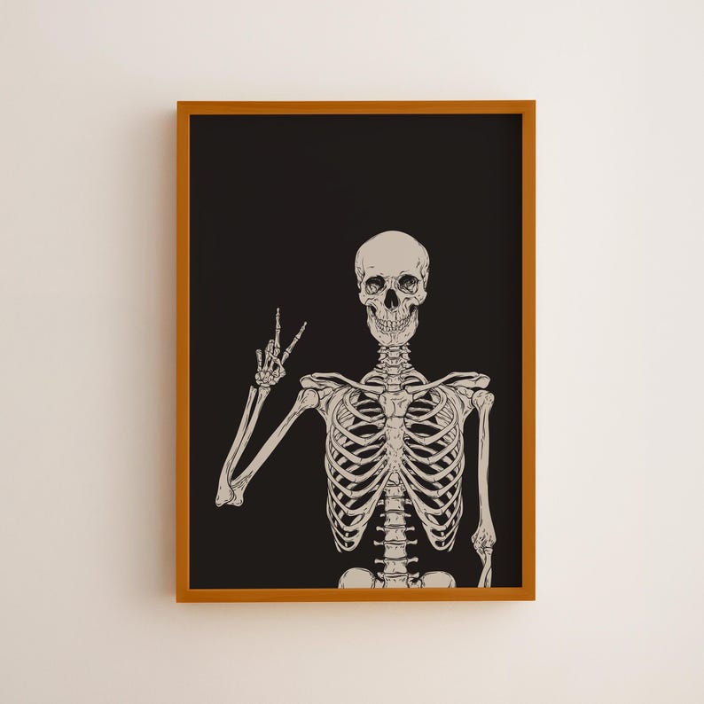 K&ouml;nnte beinhalten: Ein gerahmter Wandkunstdruck mit einer beigefarbenen Illustration eines menschlichen Skeletts vor einem einfarbigen schwarzen Hintergrund. Das Skelett ist ab der Brust aufw&auml;rts dargestellt, wobei die rechte Hand ein Friedenszeichen zeigt, als detaillierte Strichzeichnung.
