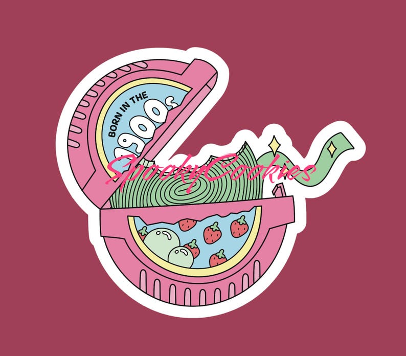 Puede incluir: Una pegatina rosa con una imagen de dibujos animados de un envoltorio de chicle con el texto "Born in the 900s" en la parte delantera. El envoltorio est&aacute; abierto y hay un chicle verde y blanco en el interior. Tambi&eacute;n hay fresas y bolas verdes dentro del envoltorio.