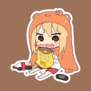 May include: A sticker featuring an anime-style character wearing an orange bear hoodie, holding a bag of chips with Japanese text. A bottle of soda and a game console are also visible. The sticker has a white border and a brown background.