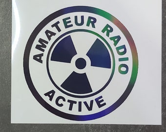 May include: A white sticker with a black circle containing the text "Amateur Radio Active" and a black and white radiation symbol.