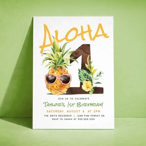 May include: A white invitation card with the word "ALOHA" in yellow script above a watercolor pineapple wearing pink sunglasses. The number "1" is brown with green leaves and yellow flowers. Text reads "Taylor's 1st Birthday!"