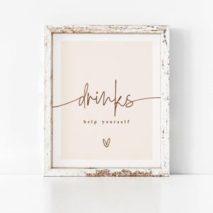 May include: A white framed sign with the text "drinks help yourself" in brown script. A small heart symbol is below the text.