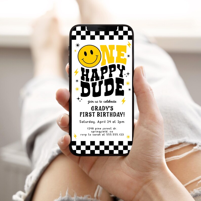 May include: A smartphone displays a birthday invitation with a retro design. The invitation reads "ONE HAPPY DUDE" with a smiley face and lightning bolt accents. The text also includes the birthday boy's name, date, time, and location.