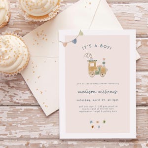 May include: A pink baby shower invitation with a cartoon train illustration. The invitation reads "It's a Boy!" and includes the text "Join us for a baby shower honoring Madison Williams, Saturday, April 24, at 2pm, Post Oak Cafe, 1248 Pine Forest Dr, RSVP to Sarah at 555-555-1234, Registered at Target & Pottery Barn."