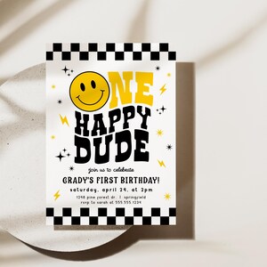 May include: A birthday invitation with a yellow smiley face and the words "ONE HAPPY DUDE" in black and yellow. The invitation includes the text "GRADY'S FIRST BIRTHDAY!" and event details. The design features lightning bolts, stars, and a black and white checkered border.