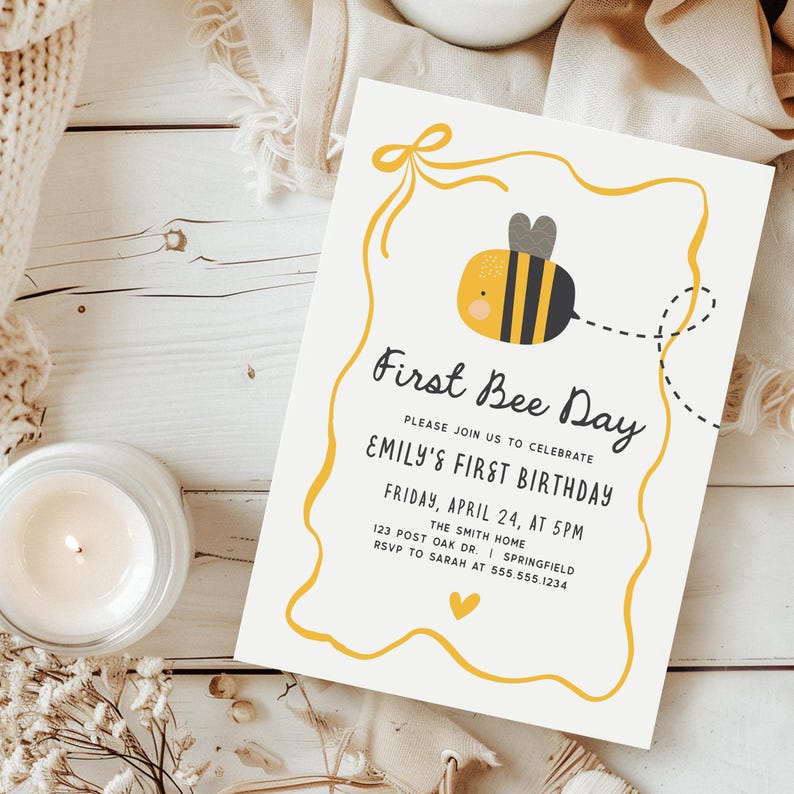 May include: A cream-colored invitation with a yellow bee illustration and the text "First Bee Day." The invitation includes details for Emily's first birthday, with a yellow border and a small heart.