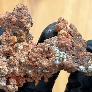 May include: A large, irregularly shaped piece of copper ore with a rough, textured surface. The ore is a mix of reddish-brown, orange, and white colors.