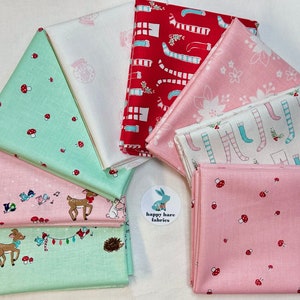 May include: A stack of eight different fabric squares with various Christmas-themed patterns. The fabrics are in shades of pink, green, white, and red. The patterns include mushrooms, reindeer, birds, and stockings.