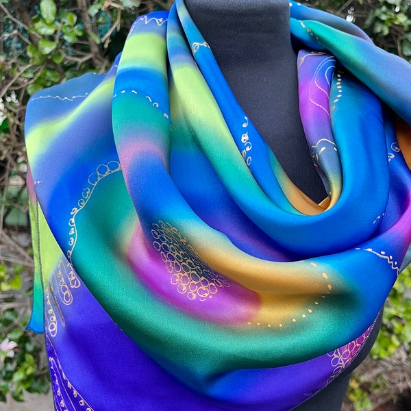 Colorful and delicate scarf, Satin silk, design of circles and spirals in color, with accents in soft and rich gold. Includes a scarf bag.