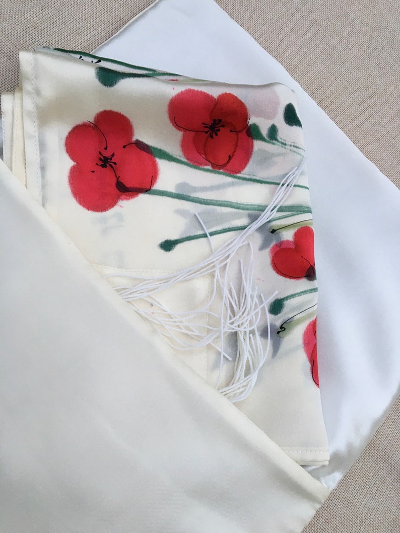 White silk Tallit, with red anemones. Includes a Tallit Bag. Can be ordered with name in Hebrew or English on the back of the bag