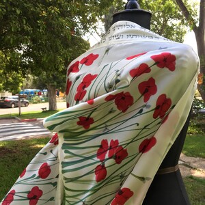 White silk Tallit, with red anemones. Includes a Tallit Bag. Can be ordered with name in Hebrew or English on the back of the bag