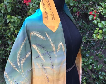 May include: A teal and gold prayer shawl with a wheat field design and Hebrew text. The shawl is draped over a black dress form.