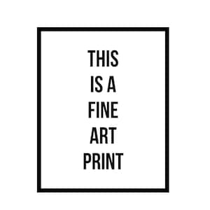 K&ouml;nnte beinhalten: Ein gerahmter Kunstdruck mit schwarzem Rahmen. Der Text "THIS IS A FINE ART PRINT" ist zentriert in fetten, schwarzen Buchstaben auf wei&szlig;em Hintergrund. Der Druck ist ein schlichtes, modernes Design.