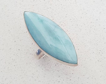 Può includere: Un anello d'argento con una pietra preziosa di forma a marquise blu chiaro.