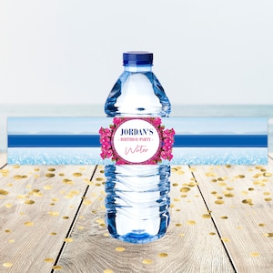 Pode incluir: Etiqueta de garrafa de água com fundo de oceano azul e branco. A etiqueta tem um design floral rosa e o texto "JORDAN'S - BIRTHDAY PARTY - Water".