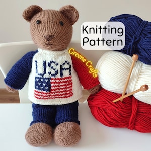 May include: Knitting pattern for a brown teddy bear wearing a blue and white sweater with the word "USA" and an American flag design. The pattern is available for purchase on Etsy. The image also shows red, white, and blue yarn balls and knitting needles.