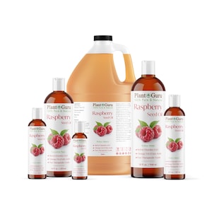 May include: A collection of Plant Guru raspberry seed oil bottles and a large jug. The bottles vary in size and feature labels with raspberry illustrations and text. The oil is amber-colored, and the labels state "100% Pure & Natural".