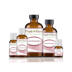 May include: A collection of amber glass bottles of essential oil, labeled "Ravensara" and "Plant Guru." The bottles vary in size, from small vials to larger containers, with black caps and white labels. The labels include the botanical name and volume.