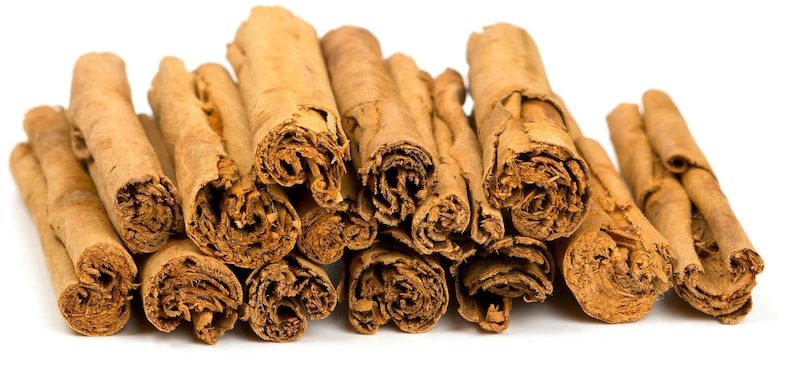 Op de afbeelding: Een verzameling kaneelstokjes, die hun gerolde vorm en warme bruine kleur laten zien. De afbeelding benadrukt de textuur en het natuurlijke uiterlijk van de specerij, perfect voor culinair gebruik of decoratieve doeleinden.