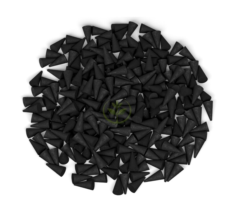 May include: A large pile of black incense cones, each with a conical shape and a textured surface. The cones are densely packed together against a white background, creating a visually striking contrast.