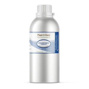 May include: A silver metal bottle with a white cap and a label that reads "Chamomile German" and "100% Pure Essential Oil." The label also includes the Plant Guru logo and states the contents are 16 fl oz / 1 lb. The bottle is cylindrical.