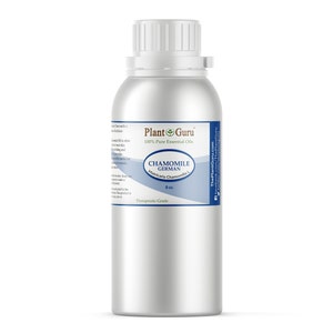 May include: A silver metal bottle of Chamomile German essential oil from Plant Guru. The label includes the text "100% Pure Essential Oils" and "Therapeutic Grade". The bottle contains 8 oz of oil.