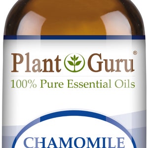 May include: A brown glass bottle of Plant Guru Chamomile German essential oil. The label includes the text "100% Pure Essential Oils" and "1/3 fl oz. (10 ml)." The bottle has a white cap.