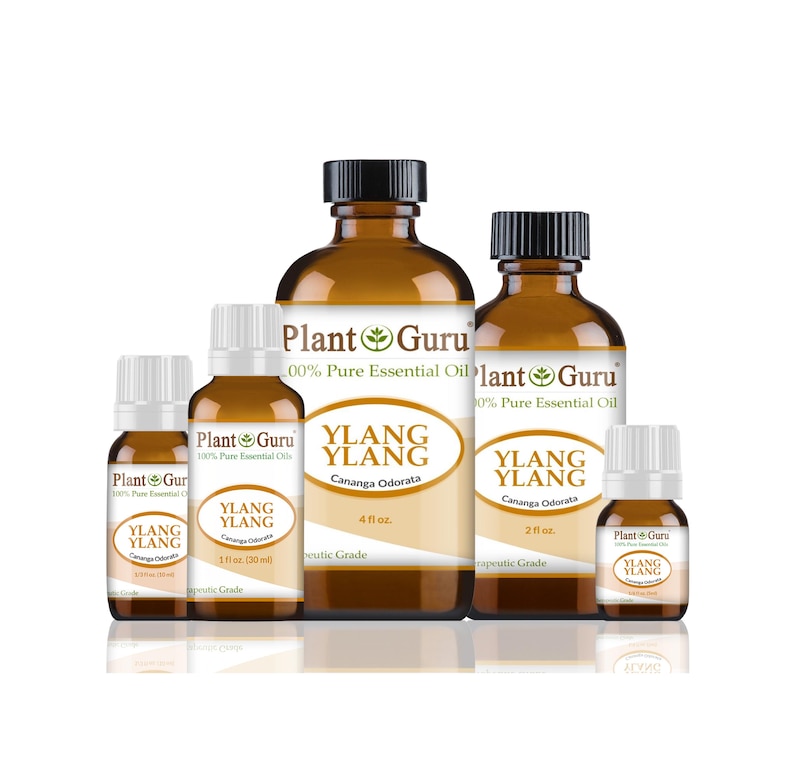 May include: A collection of amber glass bottles of Ylang Ylang essential oil, labeled "Plant Guru." The bottles vary in size, with black and white caps, and feature the text "Cananga Odorata."