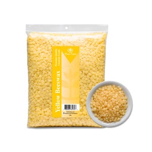 May include: A clear plastic bag filled with yellow beeswax pellets, with a small white bowl of pellets to the right. The bag has a yellow label with the words "Yellow Beeswax" and "Plant Guru". The bag is labeled as 1 lb.