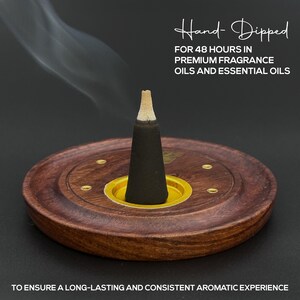 Op de afbeelding: Een zwarte wierookkegel in een houten houder met een goudkleurige basis. De houder is rond met een donkerbruine afwerking en kleine messing accenten. De tekst "Hand-Dipped" en andere tekst over het product zijn zichtbaar.