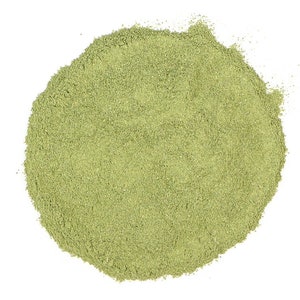 May include: A circular pile of finely ground, light green powder against a white background. The powder has a slightly textured appearance, suggesting a natural product. The image is a top-down view, highlighting the texture and color of the powder.