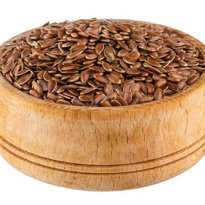 May include: A wooden bowl filled with brown flax seeds.