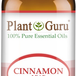May include: A brown glass bottle of Plant Guru Cinnamon Leaf essential oil. The label features the text "CINNAMON LEAF" and "1 fl oz. (30 ml)". The bottle has a white cap and is labeled "100% Pure Essential Oils".
