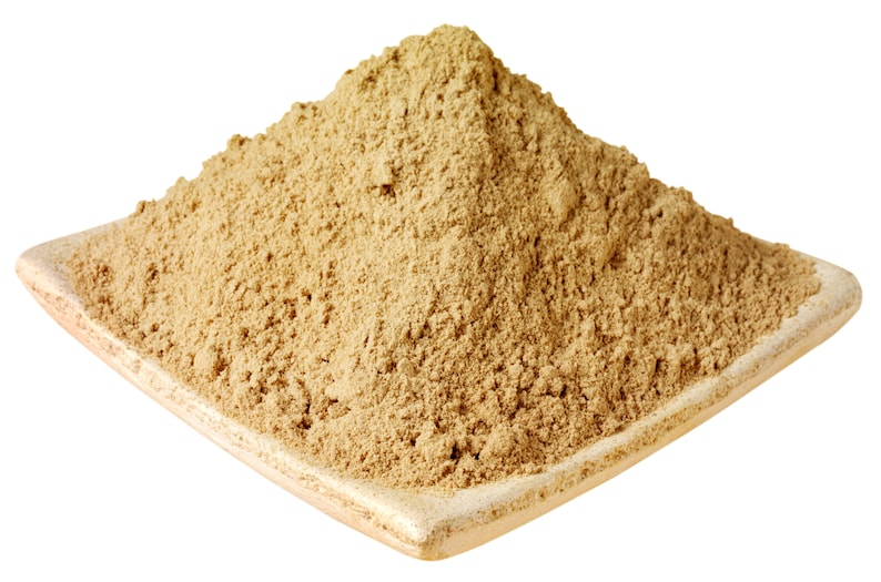 Puede incluir: Un polvo beige, posiblemente una especia o hierba, se amontona en un plato cuadrado de cer&aacute;mica de color claro. El polvo tiene una textura fina y granulada y un tono marr&oacute;n claro. El plato tiene un borde ligeramente elevado.