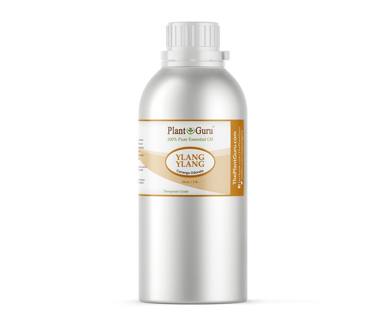 May include: A large, silver metal bottle of Ylang Ylang essential oil. The label features the text "Plant Guru 100% Pure Essential Oil" and "Ylang Ylang Cananga Odorata". The bottle contains 16 fl oz / 1 lb of oil.
