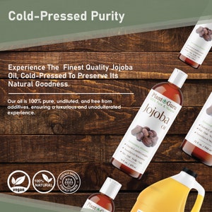 May include: Plant Guru Jojoba Oil bottles are shown against a wooden backdrop. The bottles are labelled with the text "Jojoba Oil" and "100% Pure & Natural". The image also includes text that reads "Cold-Pressed Purity" and "vegan".