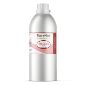 May include: A large, silver metal bottle of Plant Guru Cinnamon Leaf essential oil. The label is red and white, with the text "CINNAMON LEAF" and "32 oz. / 2 lbs.". The bottle has a white cap.