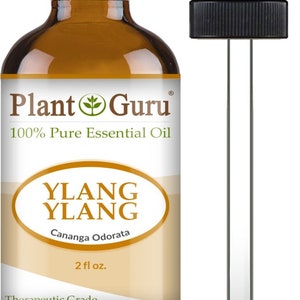 May include: A brown glass bottle of Ylang Ylang essential oil with a black dropper. The label reads "Plant Guru 100% Pure Essential Oil" and "Ylang Ylang Cananga Odorata 2 fl oz." The product is labeled as "Therapeutic Grade."