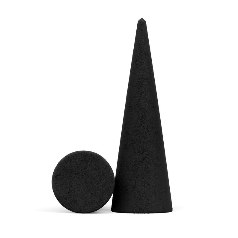 Op de afbeelding: Twee zwarte, getextureerde geometrische vormen tegen een witte achtergrond. De ene is een hoge kegel, de andere een kleine, platte cirkel. De objecten lijken van een ruw materiaal te zijn gemaakt.