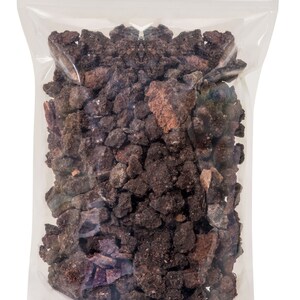 May include: A clear plastic bag filled with dark brown and reddish-brown lava rock pieces.