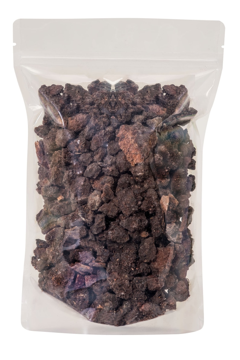 May include: A clear plastic bag filled with dark brown and reddish-brown lava rock pieces.