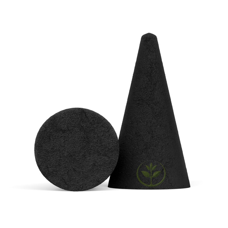 May include: A black incense cone and a circular incense holder. The cone has a textured surface and a green leaf logo. The holder is a flat disc. Both are set against a white backdrop.