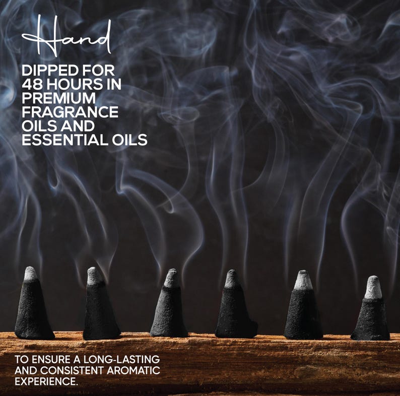 May include: Six black incense cones on a wooden surface, emitting wisps of white smoke against a dark background. Text reads "Hand dipped for 48 hours in premium fragrance oils and essential oils" and "To ensure a long-lasting and consistent aromatic experience."