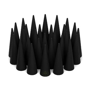 Op de afbeelding: Een verzameling zwarte wierookkegels, gerangschikt in een cirkelvormig patroon. Elke kegel heeft een puntige top en een textuur. De kegels staan tegen een witte achtergrond.
