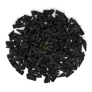 May include: A collection of black incense cones, each cone-shaped, are arranged on a white backdrop. The cones are closely packed, forming a textured surface. The image is a top-down view.
