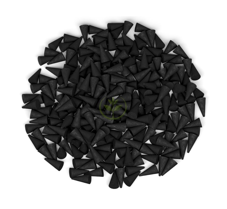 May include: A collection of black incense cones, each cone-shaped, are arranged on a white backdrop. The cones are closely packed, forming a textured surface. The image is a top-down view.
